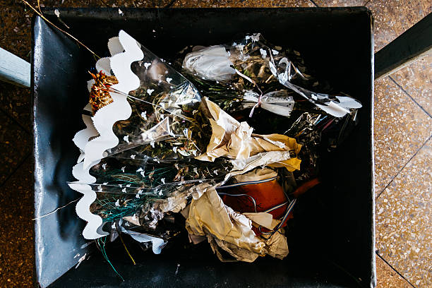 Withered flowers in a trash bin