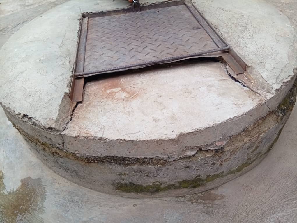 A well with a broken cover and wet sides