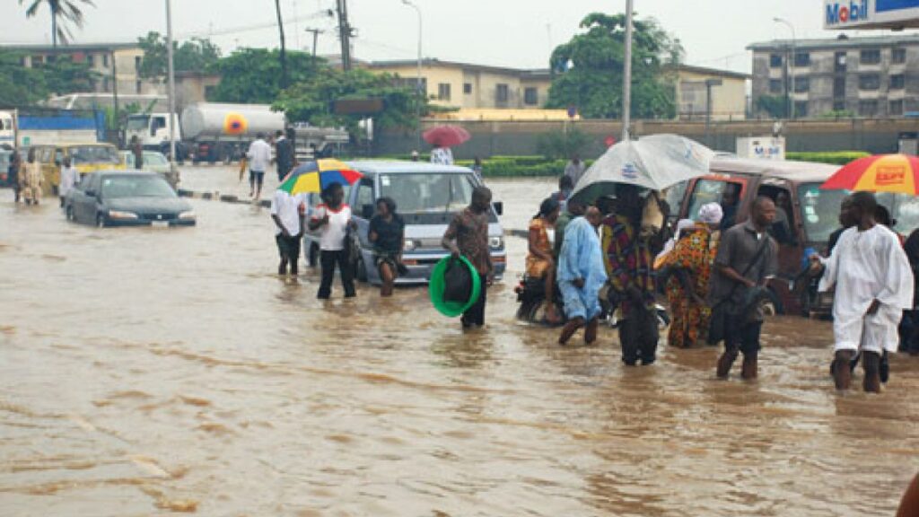 Vehicles and people moving in knee-level floodwater